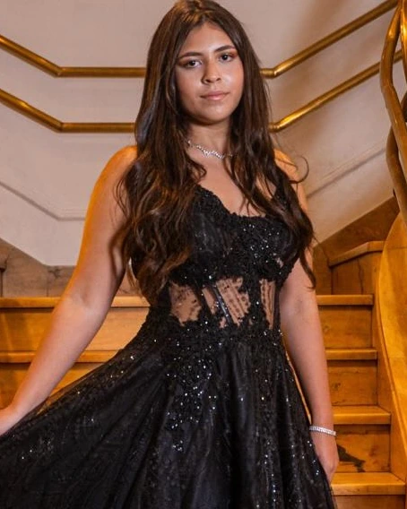 Debutante em vestido preto na escadaria durante a festa de 15 anos